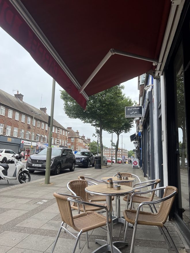 The shopfront awning and pavement tables looking out onto the high street