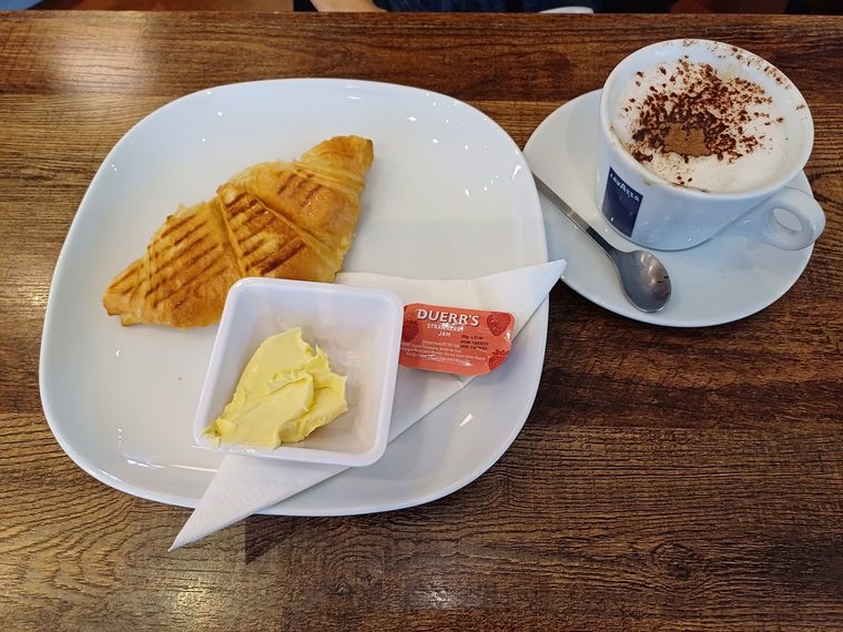 A toasted sandwich served with butter and jam portions, cropped clear of the burned-in words
