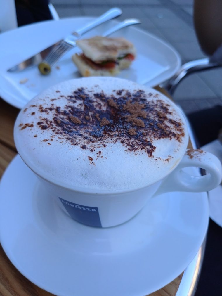 A cappuccino with a thick chocolate-dusted foam top, cropped clear of the burned-in words