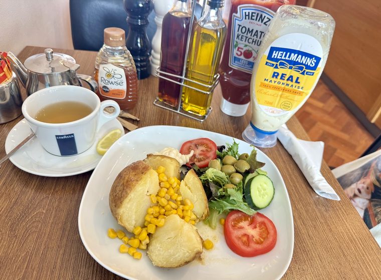 A jacket potato plate with sweetcorn and salad, cropped clear of the burned-in words